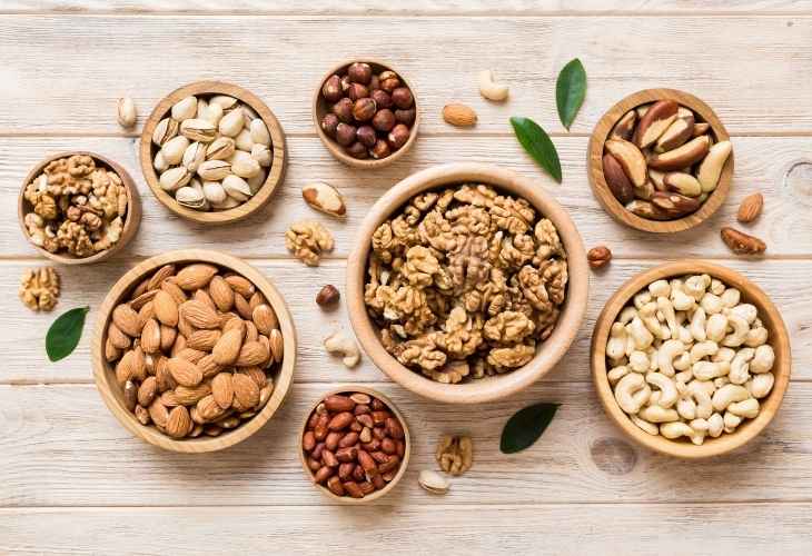 A variety of nuts in wooden bowls on a table