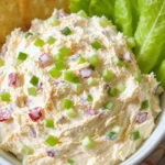 Creamy chicken salad with finely shredded chicken and minced celery, mixed in a smooth mayo base, served chilled in a white bowl with crackers and lettuce leaves on the side