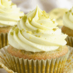 Freshly baked pistachio cupcakes with a soft green crumb, topped with creamy pistachio cream cheese frosting swirled high