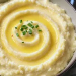 Creamy cauliflower mash in a bowl, smooth and buttery with Parmesan melted in, flecked with fresh green chives, served as a light mashed potato alternative