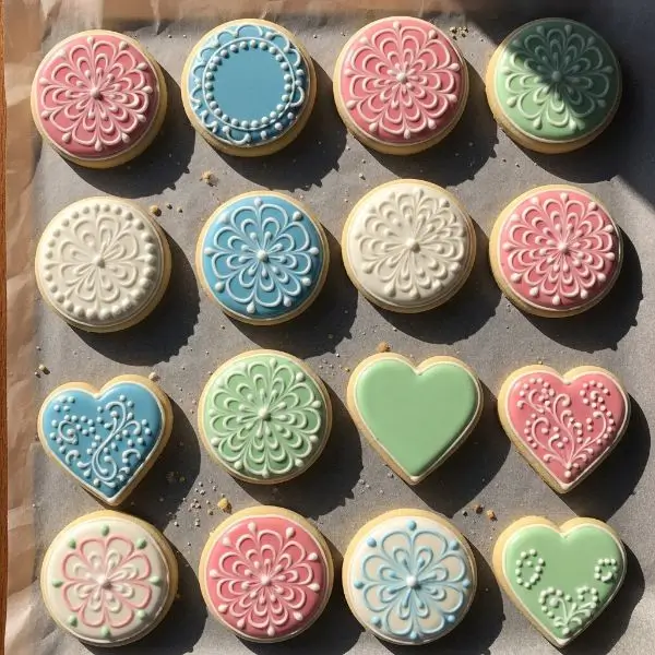 Decorated cookies laid flat on parchment, glossy icing drying