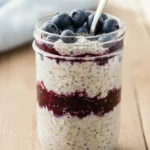 Blueberry Overnight Oats in mason jar with spoon