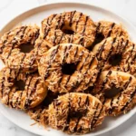 Plate of homemade Samoas cookies showing crisp shortbread rings topped with golden toasted coconut caramel