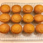 Domed gluten free pumpkin muffins cooling on a wire rack