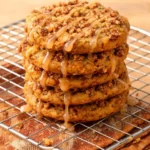 Stack of pumpkin coffee cake cookies with cinnamon streusel topping and maple glaze on a wire rack