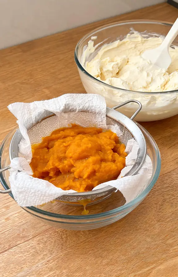 Pumpkin puree draining on paper towels next to a bowl of whipped cream cheese filling ready for a no-bake icebox cake