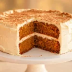 A finished two-layer pumpkin spice cake on a white cake stand